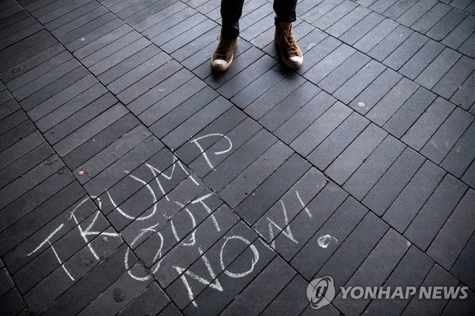 <strong>뉴욕 길바닥에 적힌 '트럼프 당장 퇴진하라' 글귀</strong><br>
(뉴욕 로이터=연합뉴스) 도널드 트럼프 미국 대통령의 극렬 지지자들이 워싱턴DC 연방의회 의사당을 점거하는 사태가 벌어진 다음 날인 7일(현지시간) 미국 뉴욕시 브루클린 바클레이스 센터 근처 길바닥에 "트럼프, 당장 꺼져!"라고 적힌 글귀가 보이고 있다. knhknh@yna.co.kr